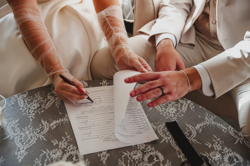 Charleston wedding photographer captures the moment the bride and groom sign their marriage license at the I'On Chapel.