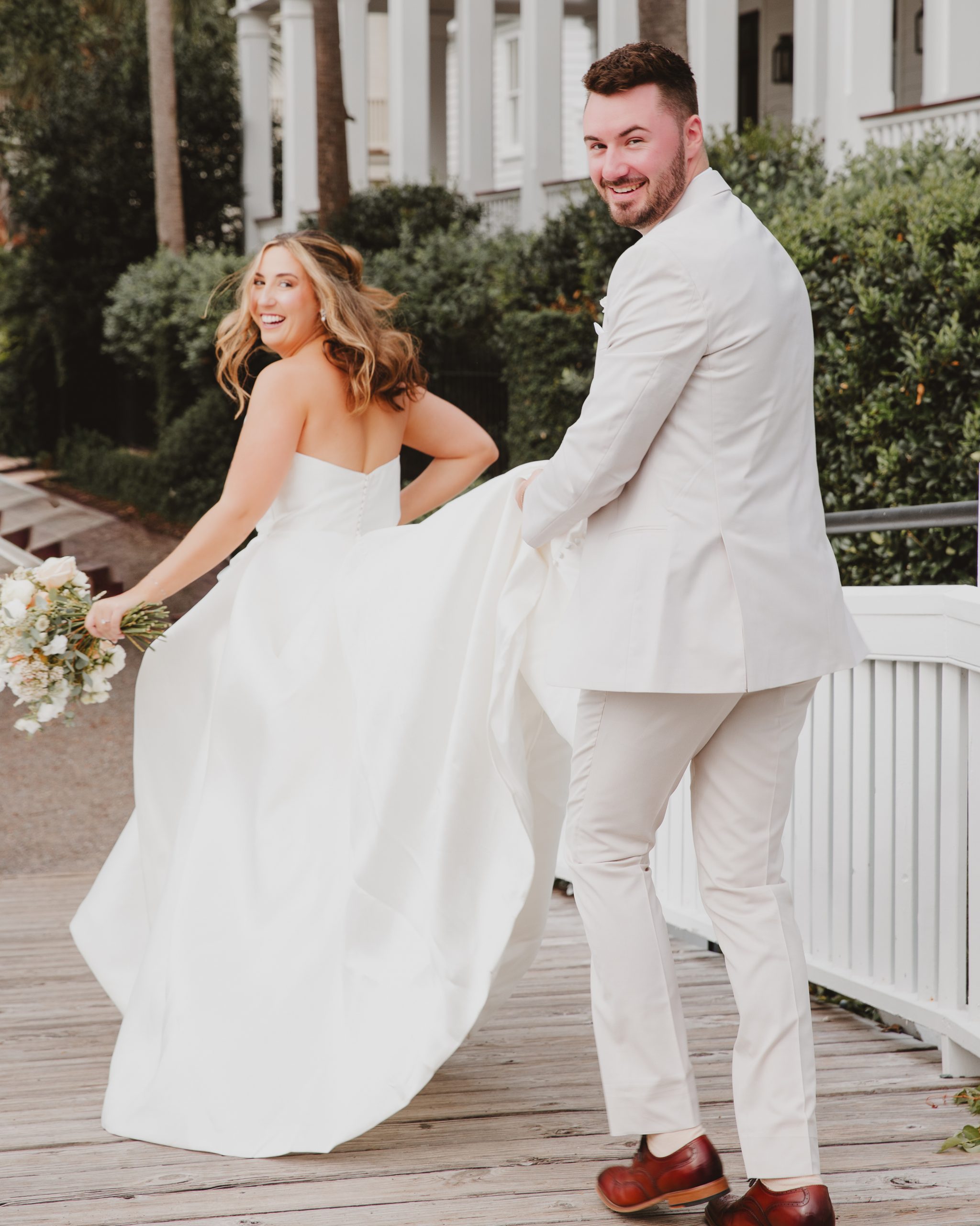 d1f77eed-74c7-4b5a-a909-a1a0cbd5fc9c Charleston wedding photography captures bride and groom candida,y running at their I'On wedding.